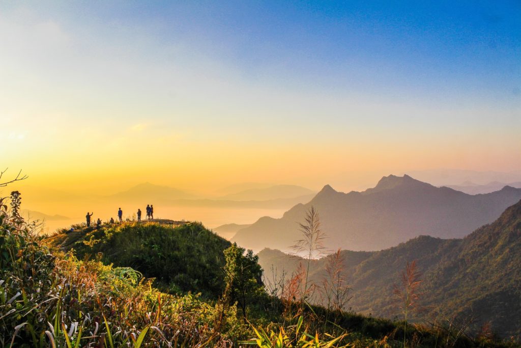 Eine Wandergruppe schaut sich den Sonnenaufgang an.